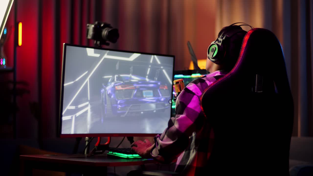 Back View Of Asian Boy Streamer Having A Backache While Playing Car Racing Game Over Network On Personal Computer. Live Stream Video Game, Desk Illuminated By Rgb Led Strip Light