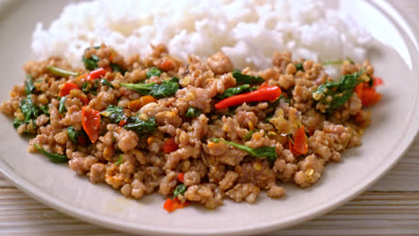 albahaca tailandesa salteada con carne de cerdo picada y chile sobre arroz coronado - estilo de comida local tailandesa