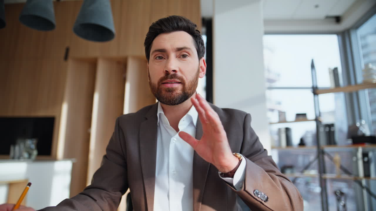 Video POV in primo piano di un mentore aziendale che parla in una conferenza virtuale, seduto in ufficio