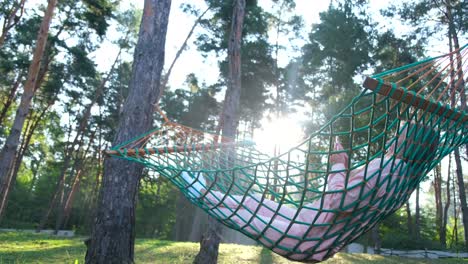 woman relaxing in a hammock in a forest