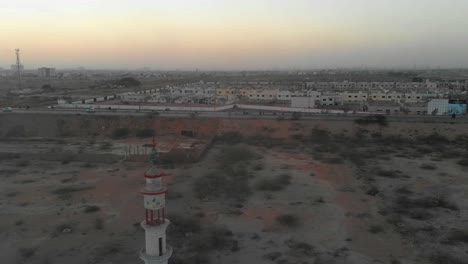 aerial view of mosque minaret next to hyderabad motorway in karachi during sunset. tracking shot