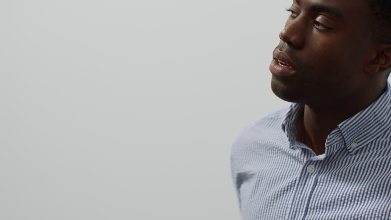 Close Up Of Young Businessman In Office Looking At Message With Bad News On Mobile Phone And Leans Against Wall Looking Unhappy And Depressed