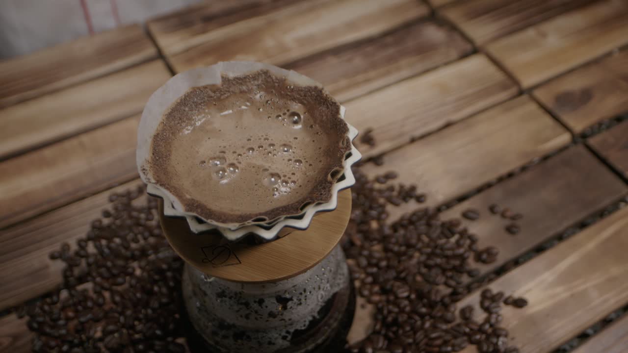 Waiting for the water to drip down, transformed into coffee, in a traditional machine captures the essence of the brewing process, blending anticipation with the rich aroma of fresh coffee