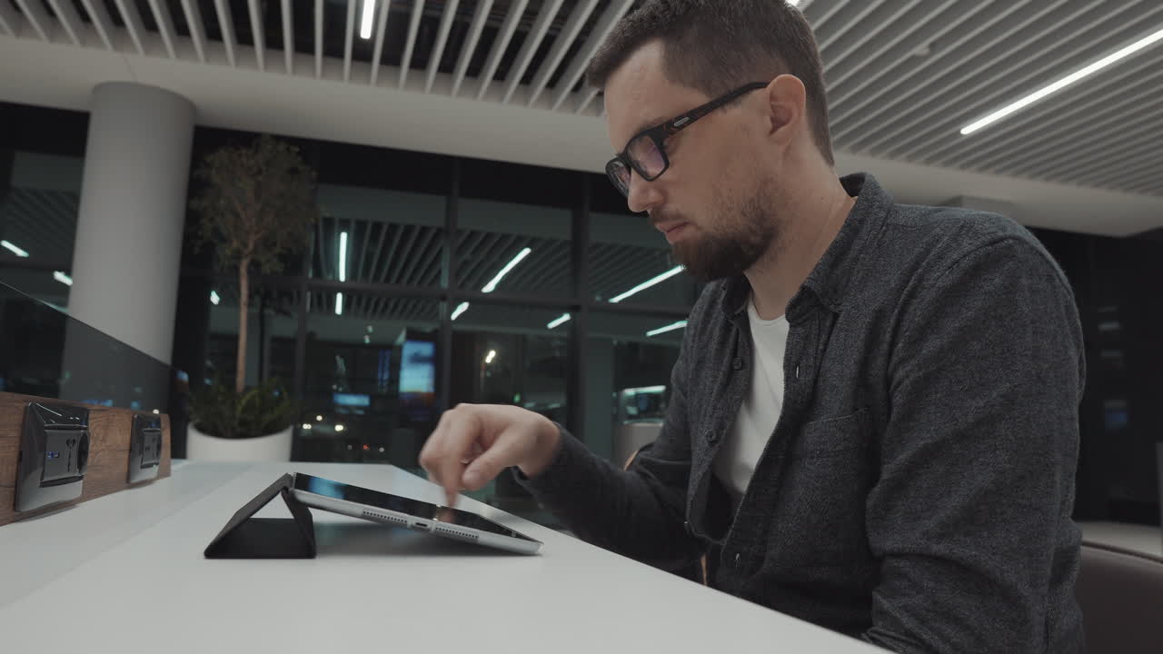 hombre usando tableta en la sala de espera del aeropuerto