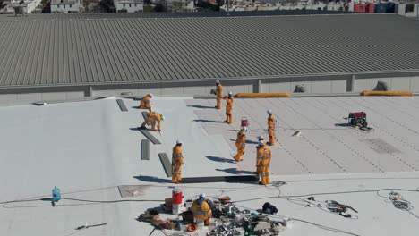 workers waterproofing an industrial rooftop