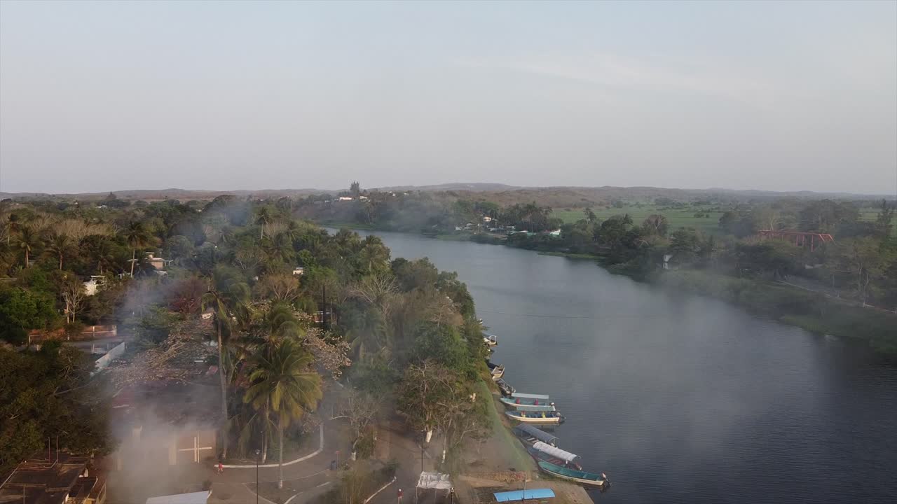 volando sobre un pueblo de pescadores en la antigua, veracruz, mexico en la tarde con un puente colgante en el fondo