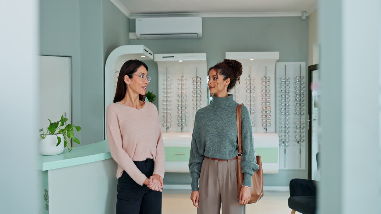 Two women choosing eyeglasses at optician