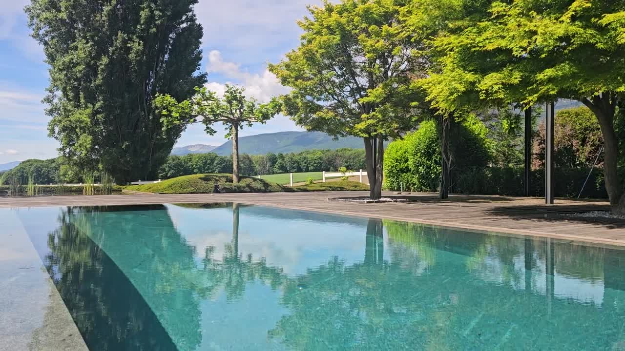 Smuk swimmingpool med grønne marker som baggrund.