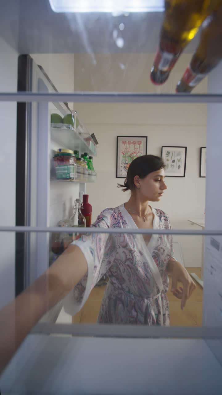 mujer buscando en el refrigerador