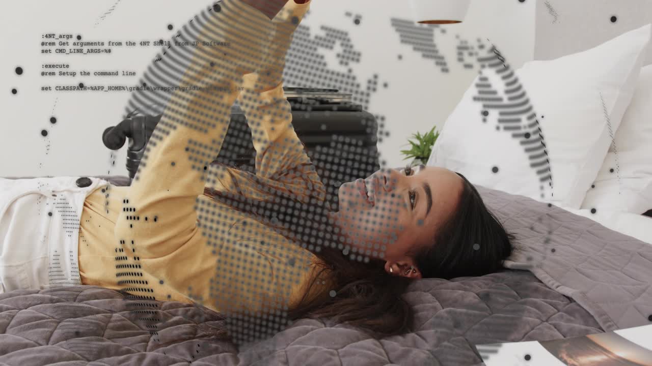 Woman lying bed holding device overhead reading and laughing as tech dotted globe overlaying face