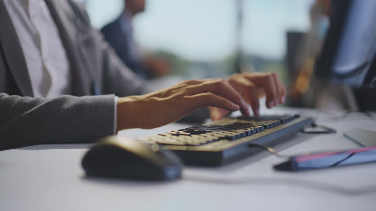persona escribiendo en un teclado de computadora en una oficina