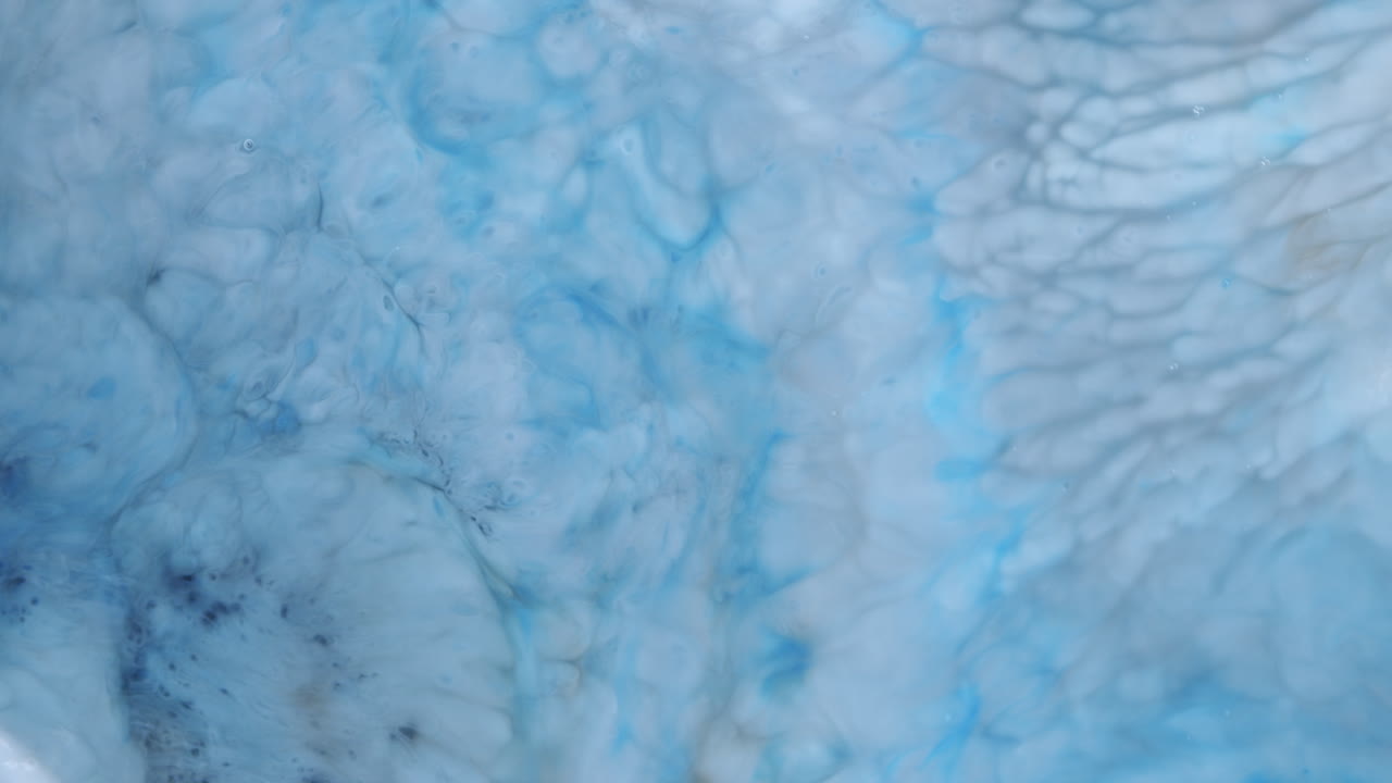 toma de lapso de tiempo de un líquido azul claro con formas orgánicas que se forman y se disuelven en el líquido