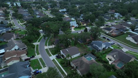 early morning in american neighborhood with luxury villas and private swimming pool. dawn in quiet suburbia of florida town. aerial top down shot