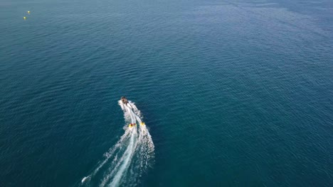 motor boat tows inflatable circle with vacationers