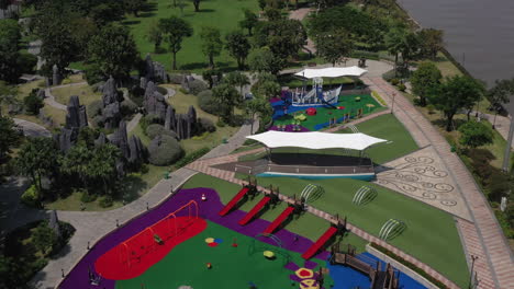 aerial view of a beautifully landscaped park on a clear sunny day with colorful children's playground tennis courts and putting green