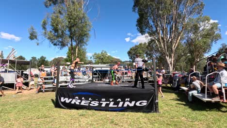 spectators watching a wrestling match outdoors