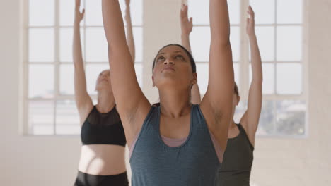 retrato de una joven embarazada de raza mixta en clase de yoga practicando pose de guerrero disfrutando de un estilo de vida saludable haciendo ejercicio en grupo en el gimnasio