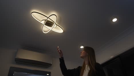 modelo femenino caminando en el cambio de temperatura de color de las luces led de techo con control remoto de blanco cálido a blanco frío y luego saliendo