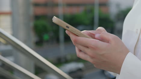 close-up of hands using a smartphone outdoors