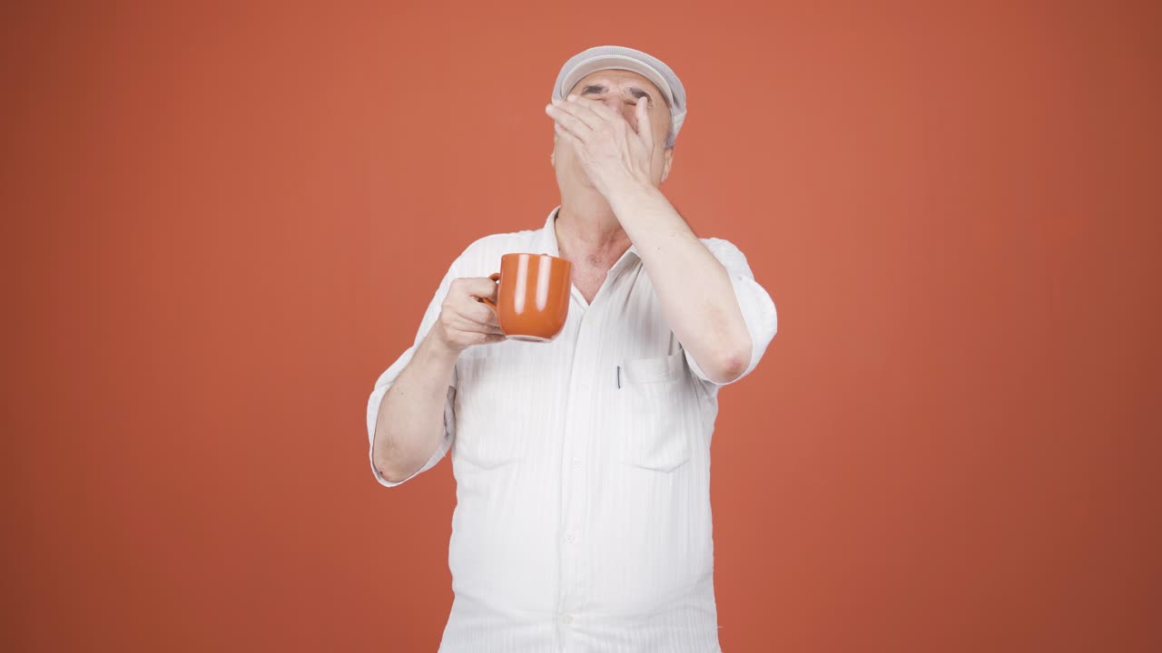 The old man's mouth is burning from the hot drink.