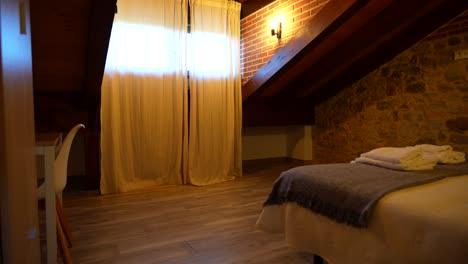 cozy rustic bedroom with stone wall and wooden beams