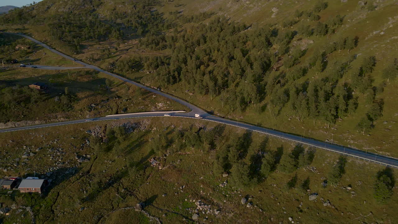 Aerial view of driving cars on road at Hardanger Plateau in Norway during sunset