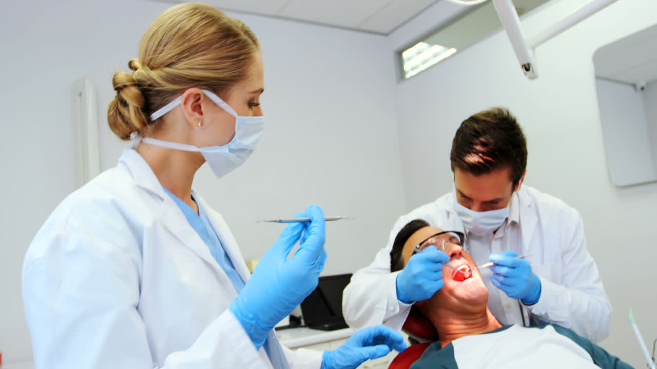 Dentists giving anesthesia to male patient