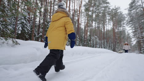 Kleiner-Junge-Rennt-Im-Verschneiten-Winterwald-Zur-Mutter.-Fröhliches-Treffen-Von-Kind-Und-Mutter