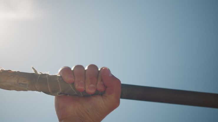 bright outdoor strength, silhouette of hand holding bar, high contrast scene with sunlight and athletic pose, inspiring outdoor training image featuring hand gripping bar against sunlit sky