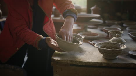 elderly woman putting out pot in workshop. senior lady drying pots in studio