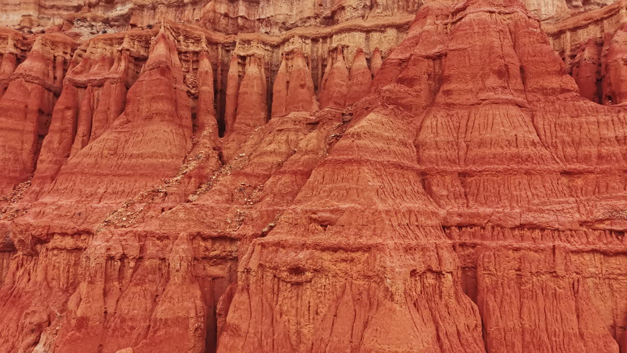 Vista delle pareti del canyon che mostrano strati di formazioni rocciose e texture, illuminate dalla brillante luce solare di giorno.