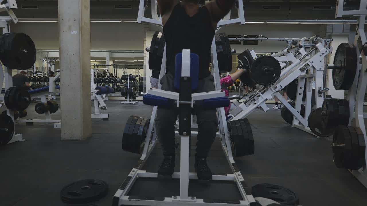 Black Male Bodybuilder Strongman Athlete Is Lifting Black Weights On Sports Equipment in 4K