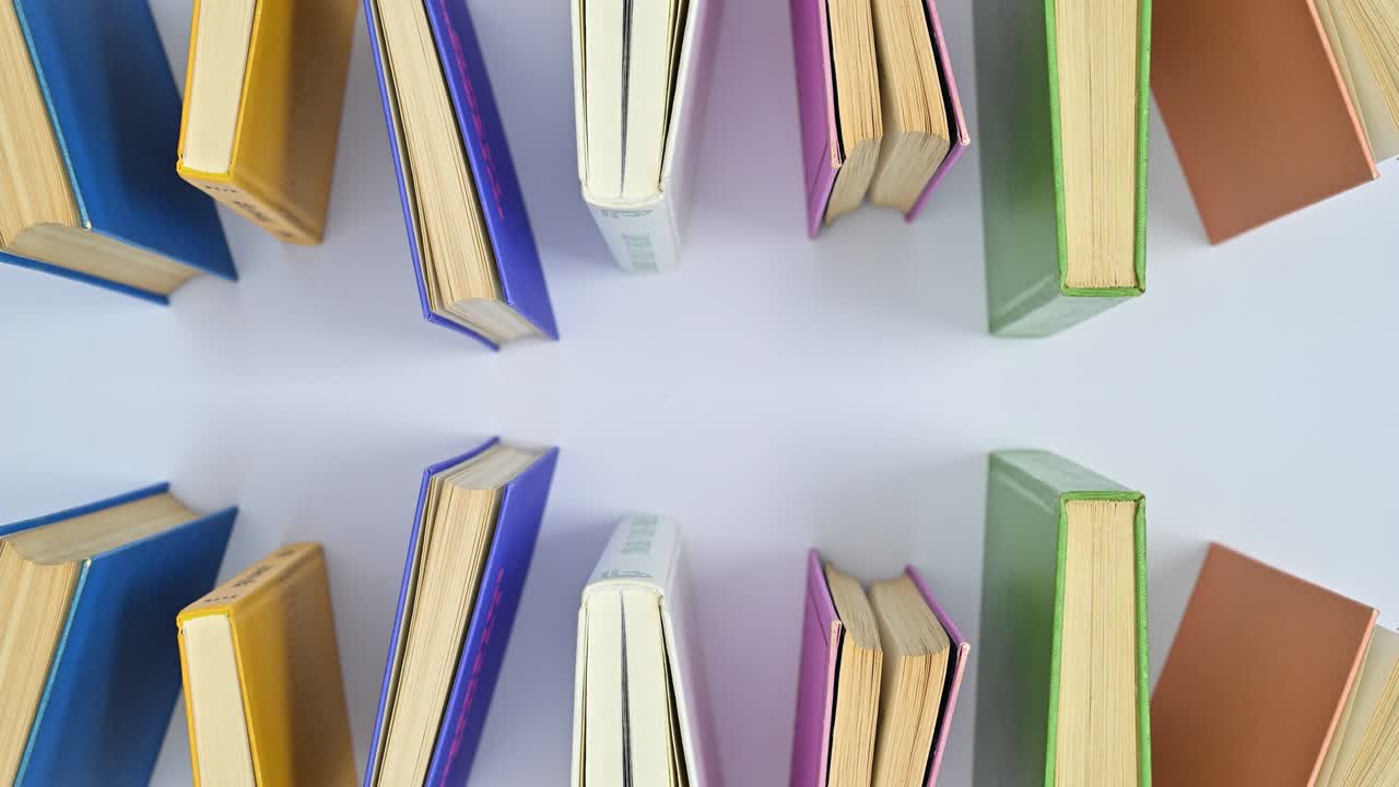 Hardcovered vintage books ordered on white theme moving. Stop motion