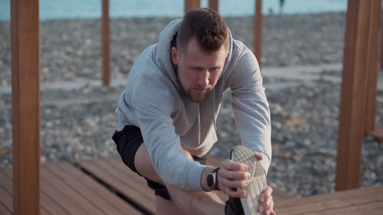 hombre estirándose en la playa