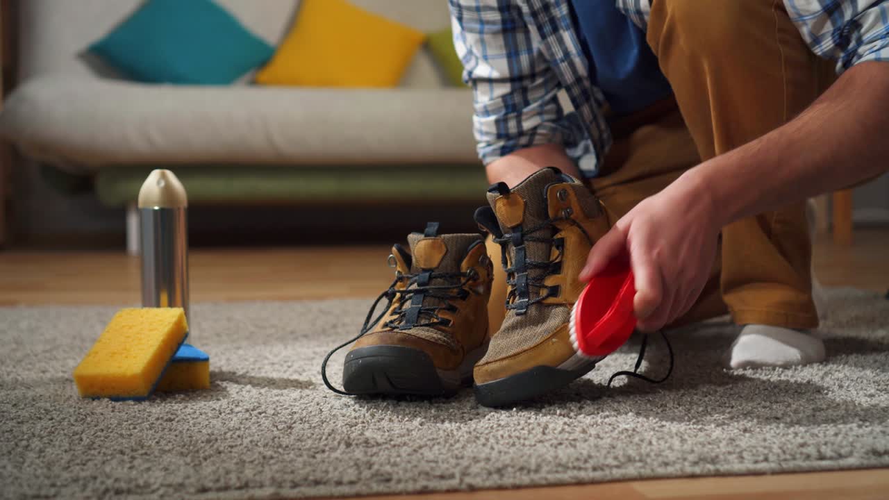hombre está ocupado en la limpieza de zapatos de la suciedad con un pincel