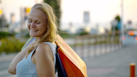 mujer sonriente con bolsas de compras al aire libre