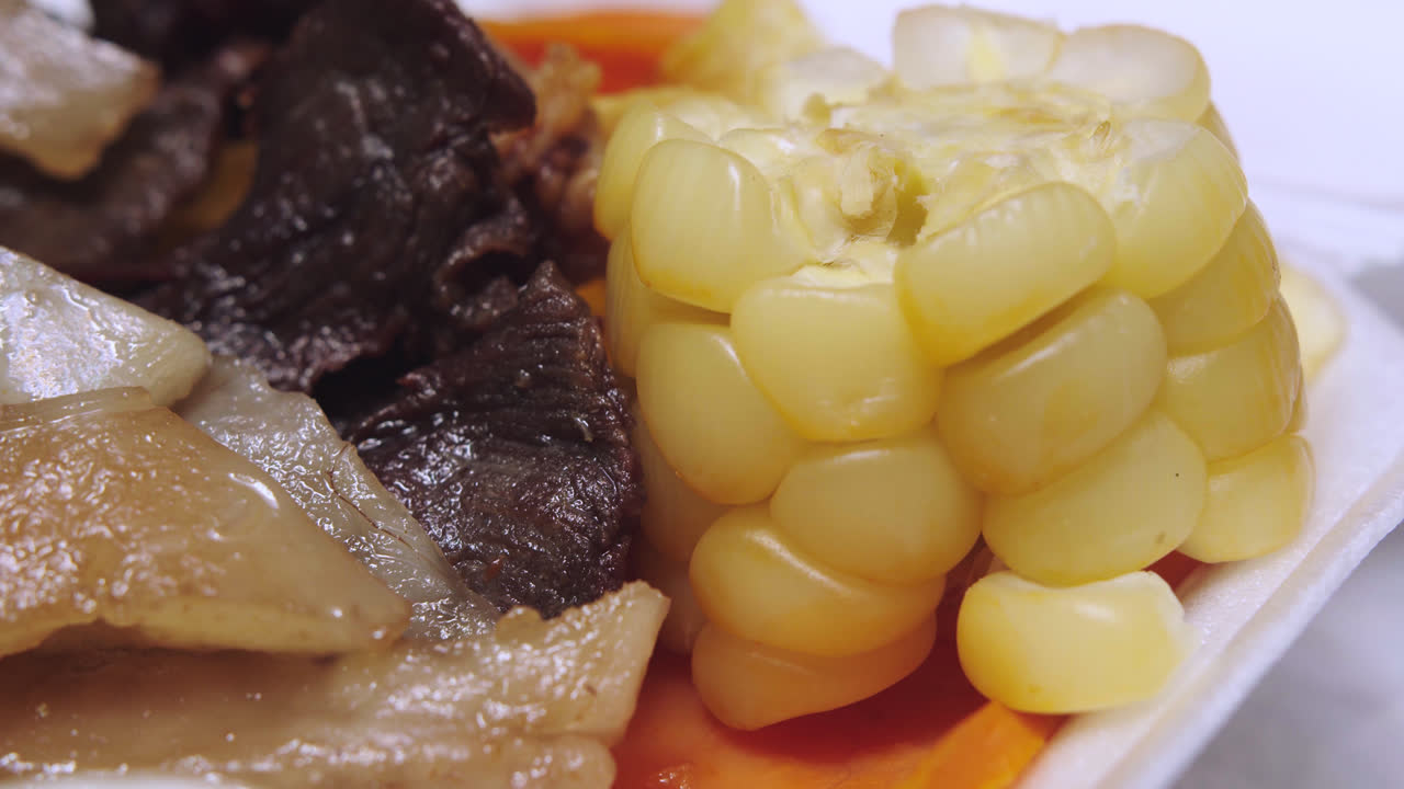 "carne seca" 접시에 있는 "maiz peruano" 또는 "elote" 클로즈업