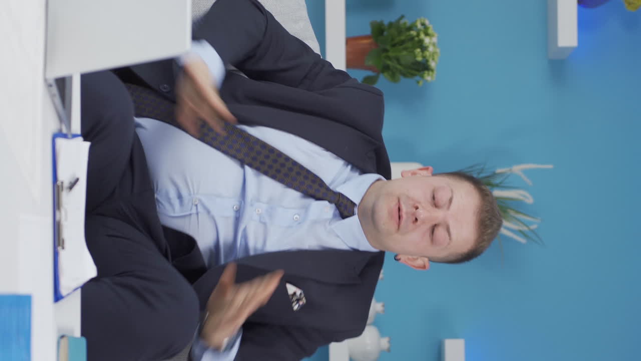 홈 오피스 근로자의 수직 비디오 남자는 피곤하고 졸리고 있습니다.