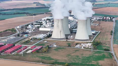 aerial view of nuclear power plant cooling towers emit vapor in atmosphere