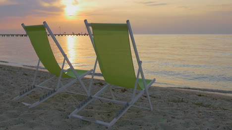 chaise longues at the seaside at sunset