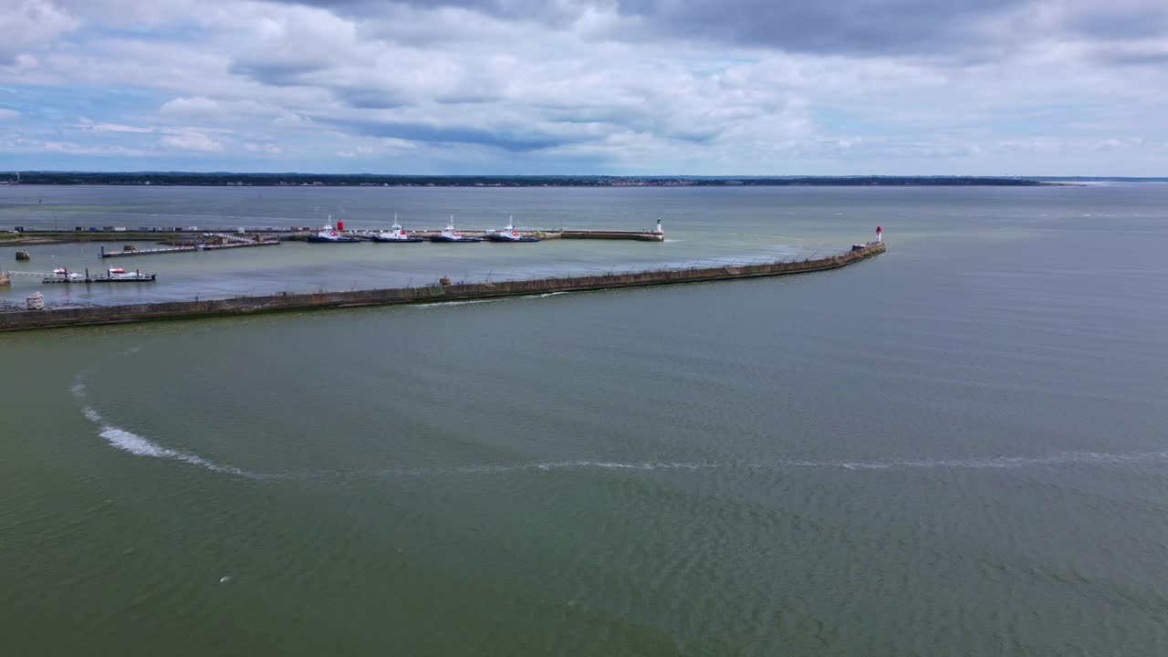 Panoramic View of a Coastal Pier, Lighthouse, and Harbor under Cloudy Sky