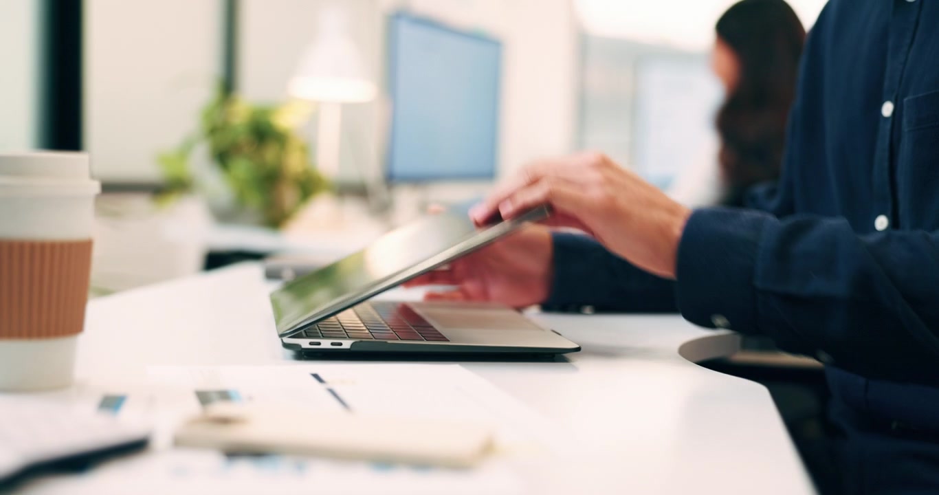 Professionel mand lukker sin bærbare computer efter endt arbejde på kontoret