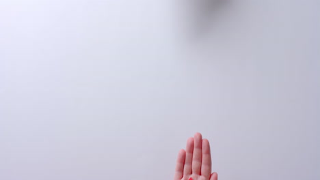 manos de personas caucásicas sosteniendo una gota de sangre sobre un fondo blanco con espacio de copia, cámara lenta