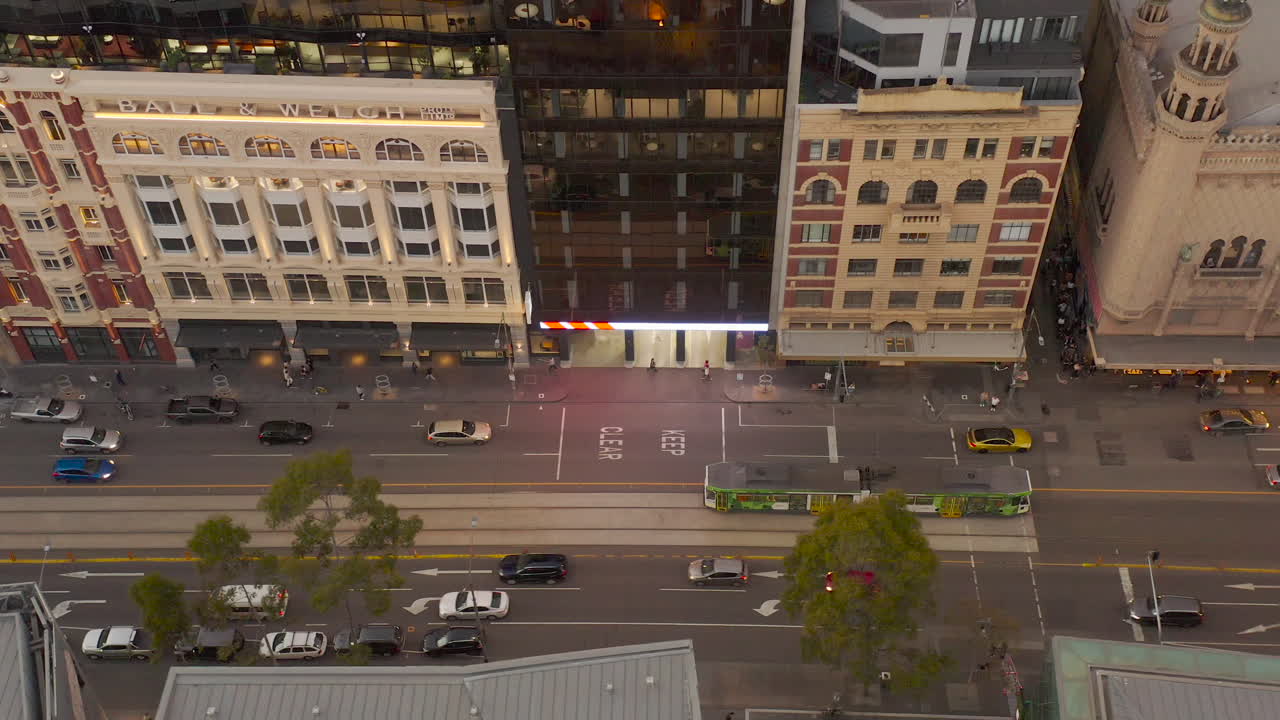 통근자와 보행자가 도시 환경을 탐색할 때 바쁜 도시 거리와 평행하게 이동하는 공중 추적 관점