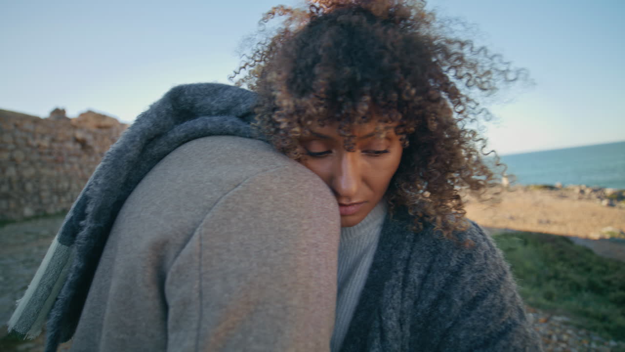 Curly girl hugging man at ocean coast closeup. Tender lovers embracing gently