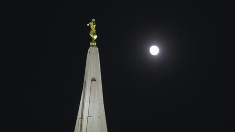 Estatua-Del-ángel-Moroni-En-La-Parte-Superior-De-Un-Edificio-De-La-Iglesia-Del-Templo-Mormón-Lds-En-La-Noche-Con-Luna-En-Gilbert,-Arizona