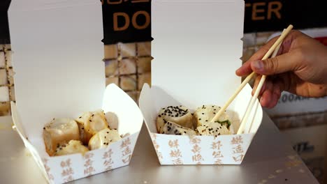 usando los palillos para recoger el dim sum