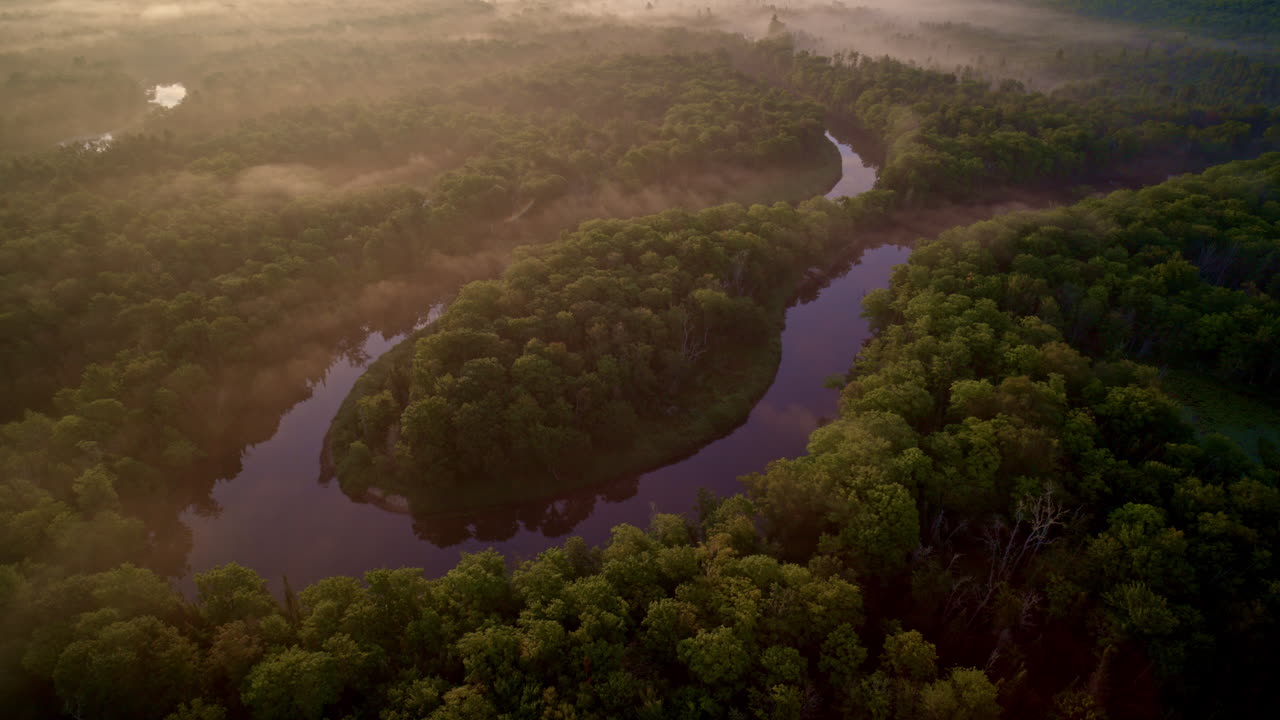 드론은 여름에 안개가 많은 아침에 미시간의 상부 반도에 있는 마니스티 강의 큰 말 모양의 곡선을 회전시키고 회전시켰다.