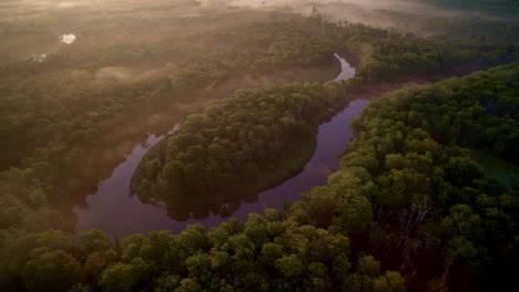 drone disparó panorámica, girando y girando sobre la gran curva en forma de herradura del río manistee en la península superior de michigan en una mañana de niebla en verano