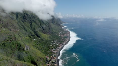 Die-Luftaufnahme-Eines-Lastwagens-Zeigt-Wolken,-Die-Sich-Auf-Dem-Berggipfel-über-Der-Küstenstadt-Auf-Madeira,-Portugal,-Angesammelt-Haben